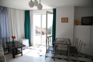 a living room with a table and chairs and a window at Popov Guest House in Balchik