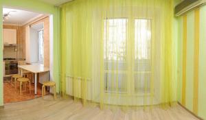オムスクにあるOmsk Sutki Apartments at Pushkina 99 floor 3の窓、テーブル、椅子が備わる客室です。