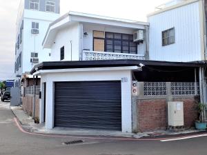 un bâtiment avec une porte de garage sur le côté d'une rue dans l'établissement Childhood Homestay, à Taïtung