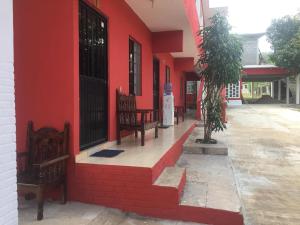 two benches sitting outside of a red building at Rincon el Mirador in Tamasopo