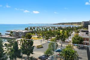 a view of a city with a parking lot and the ocean at Pier Point 105 in Geelong