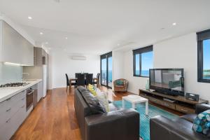 a living room with a couch and a tv at Pier Point 105 in Geelong