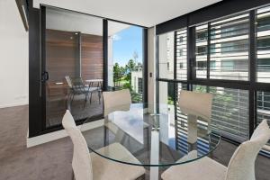 a dining room with a glass table and chairs at Edgewater 207 in Geelong
