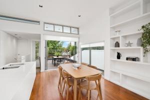 a kitchen and dining room with a wooden table and chairs at Cogens Two Bedroom Townhouse in Geelong