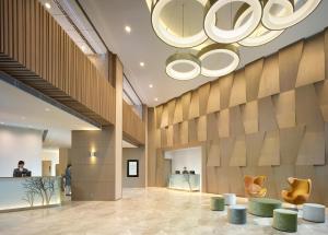 a lobby with tables and chairs and a chandelier at The Harbourview - Chinese YMCA of Hong Kong in Hong Kong