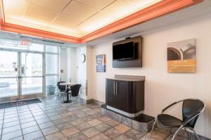 a waiting room with a tv and a table and chairs at Motel 6-Newport, TN in Newport