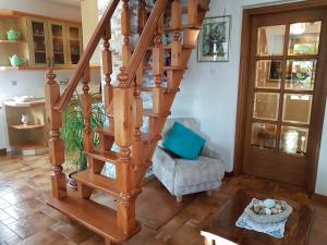 a wooden spiral staircase in a living room with a chair at Apartment Slavi in Vipava