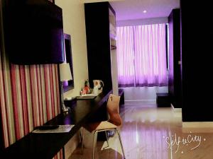 a room with a table and a chair in a room at At 24 Boutique Hotel in Nakhon Si Thammarat