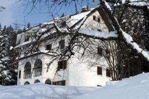 a white building in the snow with snow covered trees at Villa Kostic Kopaonik in Kopaonik