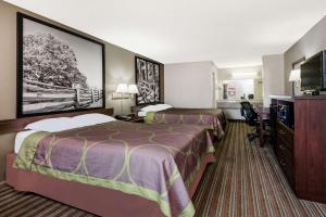 a hotel room with two beds and a flat screen tv at Super 8 by Wyndham Chattanooga Ooltewah in Ooltewah +8 photos