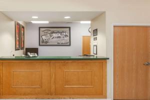 eine Rezeption in einem Krankenhauszimmer mit einer Tür in der Unterkunft Super 8 by Wyndham Huntington in Huntington