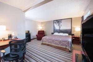a hotel room with a bed and a desk at Super 8 by Wyndham Jamestown in Jamestown