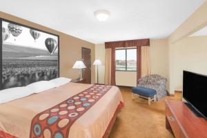 a hotel room with a bed and a tv at Super 8 by Wyndham Marshalltown in Marshalltown