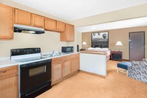 a kitchen and living room with a bed at Super 8 by Wyndham Marshalltown in Marshalltown