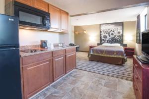 a hotel room with a kitchen and a bed at Super 8 by Wyndham Jamestown in Jamestown