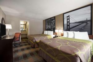 a hotel room with two beds and a bridge on the wall at Super 8 by Wyndham Salinas in Salinas +45 photos