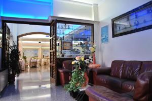 a living room with leather couches and a table at Hotel Mediterraneo in Porto Cesareo