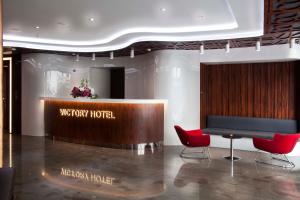 a hotel lobby with a desk and red chairs at Victory Hotel & Spa Istanbul in Istanbul +100 photos