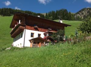 a house in the middle of a green field at Biohof Hamann in Sarntal