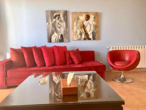 a living room with a red couch and a red chair at Stone Chalets in Fārayyā