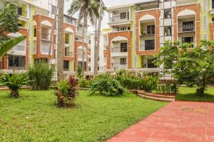 a courtyard of an apartment building with palm trees at Sun & Sand in Candolim