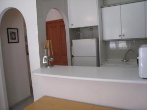 a kitchen with a white counter and a refrigerator at Apartamentos Turísticos Isla Grosa in La Manga del Mar Menor