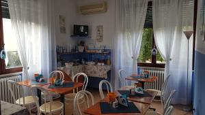 a dining room with tables and chairs and a kitchen at Hotel VILLA ITALIA B&B in Porto Azzurro