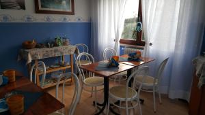 a dining room with two tables and white chairs at Hotel VILLA ITALIA B&B in Porto Azzurro