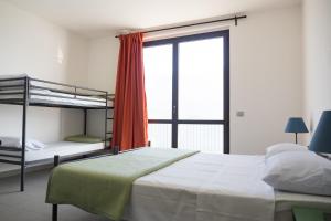Postel nebo postele na pokoji v ubytování Lake Como Beach Hostel