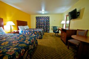 a hotel room with two beds and a desk at Passport Inn and Suites - Middletown in Middletown