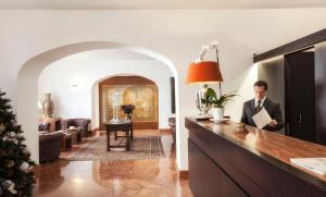 a man standing in a living room next to a kitchen at Hotel Palazzo Brunaccini in Palermo