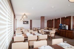 a dining room with tables and white chairs at Victory Hotel & Spa Istanbul in Istanbul
