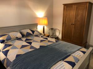 a bedroom with a bed and a lamp and a cabinet at Coast Apartment in Sidmouth