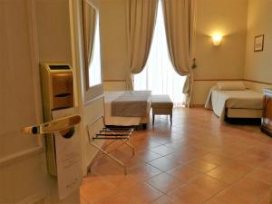 a room with two beds and a table and a chair at Hotel Nuvò in Naples