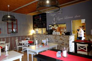 a restaurant with tables and a person standing in front of a counter at Leier apartments in Piešťany