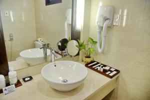 a bathroom with a sink, mirror, and bathtub at Saigon Phu Quoc Resort & Spa in Phú Quốc