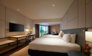 a hotel room with a large bed and a desk at PARKROYAL Penang Resort in Batu Ferringhi