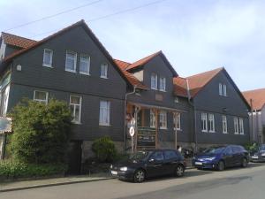 two cars parked in front of a black house at Landhotel Possendorf in Weimar