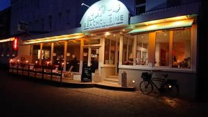 uma loja em frente à noite com uma bicicleta estacionada fora em Ria‘s Beachhouse em Borkum