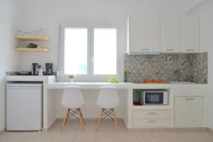 
a kitchen with a stove, sink and refrigerator at Hotel Glaronissia Rooms & Suites in Pollonia
