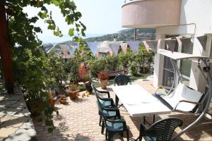 a patio with a white table and chairs and plants at Popov Guest House in Balchik