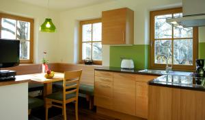 a kitchen with wooden cabinets and a table with a counter top at Villa Tilia in Siusi