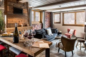 a living room with a table with wine glasses at Chalet Skadi - Village Montana in Val dʼIsère
