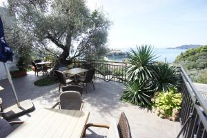 a patio with tables and chairs and a view of the water at Vila Mitrovich in Sveti Stefan
