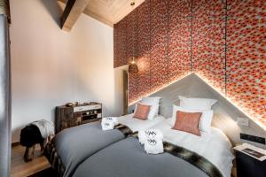 a bedroom with two beds and a red brick wall at Chalet Skadi - Village Montana in Val dʼIsère