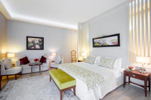 una camera con un grande letto bianco e un divano di Gabala Yengice Thermal Resort Hotel a Yengica