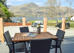 a wooden table and chairs on a deck at The Corran in Onich