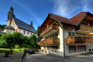 un edificio con balcones y un edificio con iglesia en Hotel dasZimmermann en Todtmoos