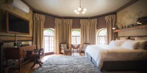 um quarto com uma cama, uma secretária e uma televisão em Schoon Huis Manor em Kempton Park