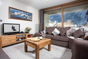 a living room with a couch and a table at Le Paradis ski apartment - Chamonix All Year in Chamonix